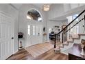 Bright foyer featuring a chandelier, hardwood floors, large window, staircase and office area beyond at 10822 Eagle Crest Ct, Parker, CO 80138