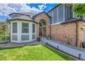 Exterior elevation of a charming home with a brick entry, and a well manicured lawn and lush, mature landscaping at 10822 Eagle Crest Ct, Parker, CO 80138