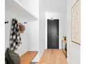 Inviting entryway with custom storage, a wooden bench, and modern decor, leading to a sleek, black front door at 1750 Wewatta St # 1825, Denver, CO 80202