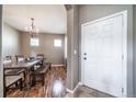 Formal dining room with chandelier lighting, hardwood floors, and view to front door at 13152 E 104Th Dr, Commerce City, CO 80022