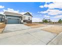 Single-Gathering home featuring blue siding, stone accents, and a two-car garage on a large, paved lot at 5726 N Jebel Way, Aurora, CO 80019