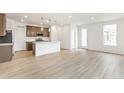 Open-concept kitchen and living area with wood floors and a center island, perfect for entertaining at 5726 N Jebel Way, Aurora, CO 80019