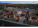 Luxury home at dusk, showcasing the architectural design and community layout with city lights and mountain views at 9487 Winding Hill Way, Lone Tree, CO 80124