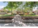 Inviting home featuring a stone retaining wall and steps leading to a well-maintained lawn at 650 Saint Paul St, Denver, CO 80206