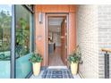 Stylish front entrance featuring a modern wood door, brick accents, and lush potted plants at 4200 W 17Th Ave # 53, Denver, CO 80204
