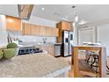 Well-lit kitchen featuring granite countertops, stainless steel appliances, wood cabinets, and hardwood flooring at 410 Acoma St # 309, Denver, CO 80204