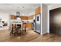 Modern kitchen features light wood cabinets, a breakfast bar with stools, and stainless steel appliances at 410 Acoma St # 309, Denver, CO 80204