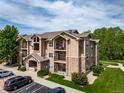 Exterior of condo building with private balconies and well-manicured lawn at 10787 Twenty Mile Rd # 205, Parker, CO 80134