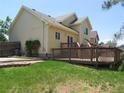 A sprawling backyard showcasing a wooden deck, lush green lawn, and mature trees at 19421 E Evans Dr, Aurora, CO 80013