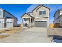 Two-story house with gray siding, attached garage, and landscaping at 17771 E 93Rd Ave, Commerce City, CO 80022