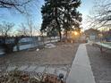 Spacious backyard with a stone path, garden beds, and a metal fence at 2602 Jasmine St, Denver, CO 80207