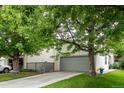 Picture of house exterior with a green lawn, mature trees and a gray two-car garage at 1633 S Trenton St, Denver, CO 80231