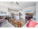 Open-concept space featuring wood floors, modern furniture, and seamlessly connecting the living area to the kitchen at 19733 W 93Rd Ln # A, Arvada, CO 80007