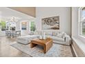 Bright living room with modern decor, large sectional sofa, and stylish accent rug and artwork at 1261 E 135Th Pl, Thornton, CO 80241