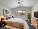 Virtually staged main bedroom with wood floors and large window at 445 Tumbleweed Dr, Brighton, CO 80601