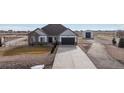 Charming single-story home featuring stone accents, a long driveway, and a detached garage at 11200 E 166Th Ave, Brighton, CO 80602