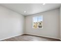 Bright bedroom with wood floors and a window overlooking the neighborhood at 1416 Orchard St, Brighton, CO 80601