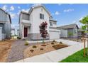 Charming two-story home with a two-car garage, landscaped front yard, and attractive white and gray exterior at 1416 Orchard St, Brighton, CO 80601