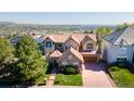Beautiful aerial view of a stone home showcasing its tile roof and mature landscaping at 16713 W Archer Ave, Golden, CO 80401