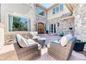 Cozy front patio with stylish wicker furniture and a stone accent wall at 16713 W Archer Ave, Golden, CO 80401