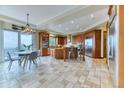Spacious kitchen with travertine floors, wooden cabinets and a center island with seating at 16713 W Archer Ave, Golden, CO 80401
