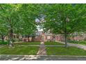 Charming Tudor home with brick exterior, manicured lawn, and mature trees at 2065 Leyden St, Denver, CO 80207