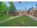 Charming brick home featuring a well-maintained lawn and a classic architectural style at 2065 Leyden St, Denver, CO 80207