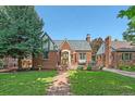 Traditional brick home with a neatly landscaped front yard and inviting front porch at 2065 Leyden St, Denver, CO 80207