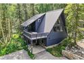 A-frame home with a large deck surrounded by lush green trees at 6365 Highway 9, Breckenridge, CO 80424