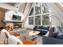 Cozy living room with a stone fireplace and large windows offering scenic views at 6365 Highway 9, Breckenridge, CO 80424