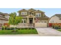 Charming two-story home with a manicured lawn, covered porch and an attached garage at 16043 Fillmore St, Thornton, CO 80602