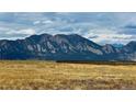 Scenic view of mountains and open field under a cloudy sky at 1747 High Plains Ct, Superior, CO 80027