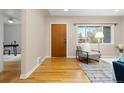 Bright living room featuring hardwood floors, a modern chair, a large window, and a stylish door at 3230 Vance St, Wheat Ridge, CO 80033