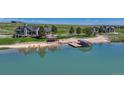 Aerial view of a lakeside property, featuring a private dock, gazebo, kayaks, and manicured grounds at 6234 Nautique Cir, Larkspur, CO 80118