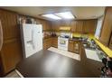 Well-lit kitchen features a full-sized refrigerator, plentiful wood cabinets, a window, and tiled floors at 14828 E Pacific Pl, Aurora, CO 80014