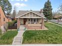 Attractive home featuring a cozy front porch and a well-maintained yard at 2900 Clermont St, Denver, CO 80207