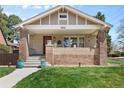 Charming home with inviting front porch, featuring brick accents and well-manicured lawn at 2900 Clermont St, Denver, CO 80207