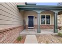 Inviting front porch with brick accents, providing a warm welcome to this lovely home at 17522 E Dewberry Dr, Parker, CO 80134
