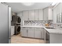 Modern kitchen with grey cabinets, stainless steel appliances, and marble backsplash at 4728 Dover St, Wheat Ridge, CO 80033