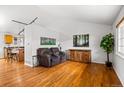 Bright living room featuring hardwood floors, vaulted ceiling, and comfortable seating at 3811 E 138Th Pl, Thornton, CO 80602