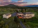 Scenic aerial view of backyard featuring pool, basketball court, and a beautifully landscaped yard at sunset at 3485 Park Ridge Rd, Sedalia, CO 80135