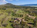 Aerial view highlighting the property outline, showcasing the main house, barn, and expansive green landscape at 3485 Park Ridge Rd, Sedalia, CO 80135