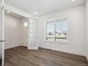 Well-lit room with hardwood flooring, a window, and a door with glass panes at 1860 Chaffee Crest Dr, Berthoud, CO 80513