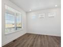 Bright room with hardwood floors and a large window with horizontal blinds at 1860 Chaffee Crest Dr, Berthoud, CO 80513