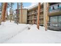 Multi-level condo building showcasing balconies and snow-covered walkway and surroundings at 1173 Ski Hill Rd # 127, Breckenridge, CO 80424