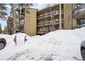 Exterior of a condo building with snow-covered parking lot in foreground at 1173 Ski Hill Rd # 127, Breckenridge, CO 80424