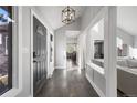 Inviting entryway with modern light fixture, wood floors, and an open view into the spacious interior of the home at 7863 Windfont Row, Parker, CO 80134