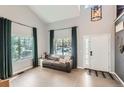Bright living room features a vaulted ceiling, large windows, and modern decor, creating a welcoming and stylish space at 3805 E 106Th Ave, Thornton, CO 80233