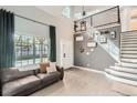 Spacious living area with high ceilings, modern decor, and an open staircase, creating a bright and inviting atmosphere at 3805 E 106Th Ave, Thornton, CO 80233