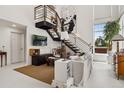 Spacious living room with modern staircase, white walls, large windows, art, and zebra bench at 790 N Clarkson St # 206, Denver, CO 80218